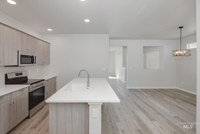 kitchen with a sink, decorative backsplash, light countertops, modern cabinets, and appliances with stainless steel finishes