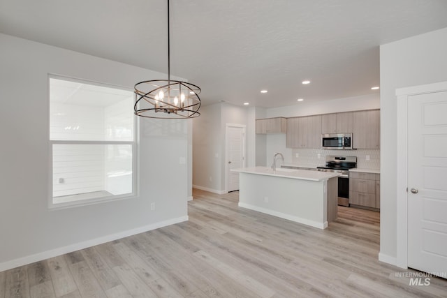 kitchen featuring stainless steel appliances, tasteful backsplash, light wood finished floors, light countertops, and modern cabinets