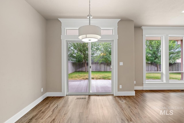 13991 W Milford Dr, Boise, ID 83713 - unfurnished dining area with healthy amount of natural light, baseboards, and wood finished floors