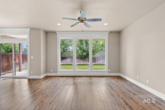 13991 W Milford Dr, Boise, ID 83713 - empty room with wood finished floors, plenty of natural light, a ceiling fan, recessed lighting, and a textured ceiling