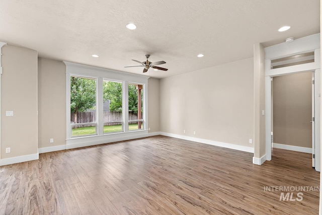 13991 W Milford Dr, Boise, ID 83713 - unfurnished living room with a ceiling fan, wood finished floors, baseboards, recessed lighting, and a textured ceiling