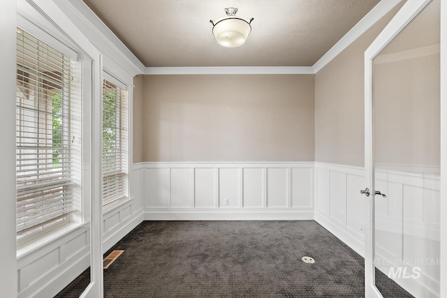 13991 W Milford Dr, Boise, ID 83713 - unfurnished room with dark carpet, a wainscoted wall, crown molding, and a decorative wall
