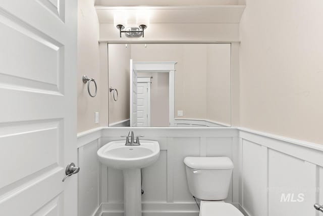 13991 W Milford Dr, Boise, ID 83713 - half bath featuring a decorative wall, toilet, wainscoting, and a sink
