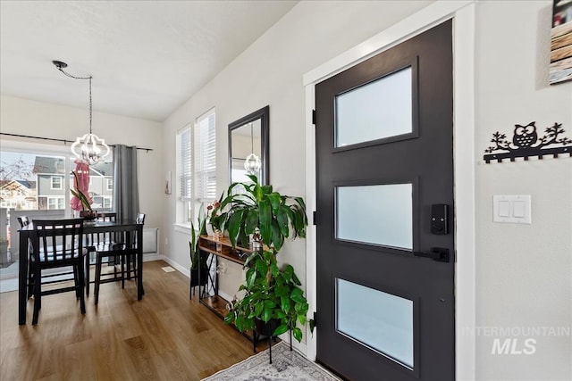 entryway featuring wood-type flooring and a notable chandelier