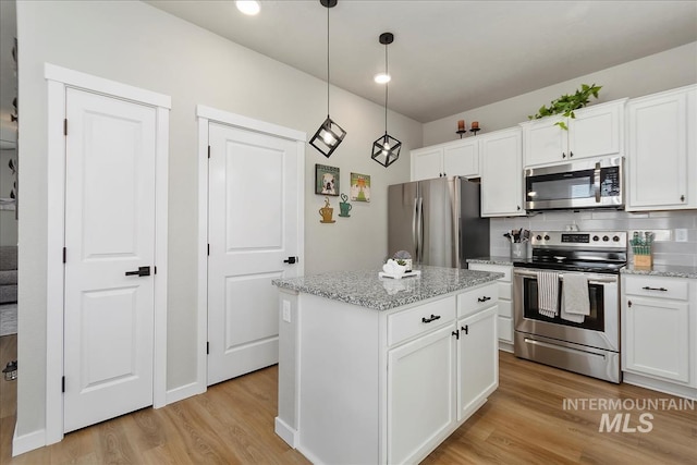 kitchen with white cabinetry, stainless steel appliances, and a kitchen island