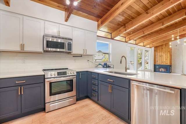 167 W Robbins, Twin Falls, ID 83301 - kitchen featuring appliances with stainless steel finishes, a wooden ceiling with exposed beams, decorative backsplash, and light countertops