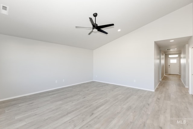 unfurnished room featuring light wood finished floors, visible vents, baseboards, vaulted ceiling, and a ceiling fan