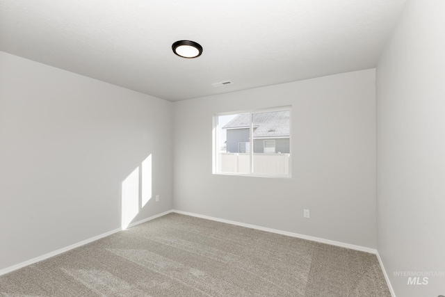 empty room featuring visible vents, baseboards, and carpet floors