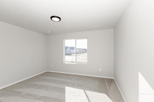 carpeted empty room with baseboards and visible vents