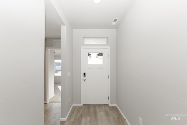 foyer entrance with visible vents, baseboards, and light wood finished floors