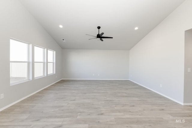 unfurnished room featuring baseboards, lofted ceiling, light wood-style flooring, and a ceiling fan