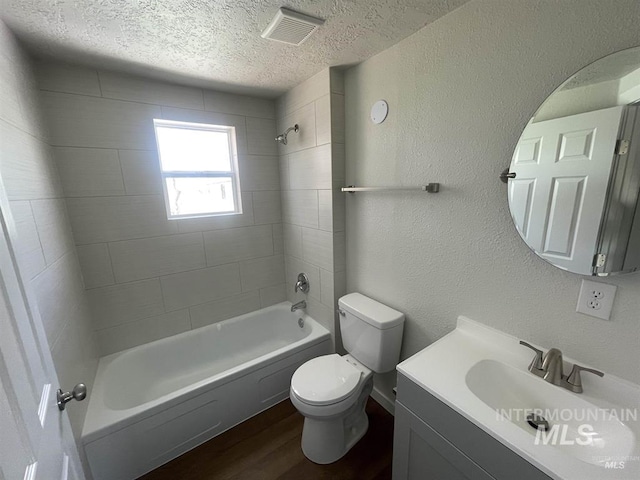 956 SE Hamilton Rd, Mountain Home, ID 83647 - bathroom with wood finished floors, toilet, shower / tub combination, vanity, and a textured ceiling