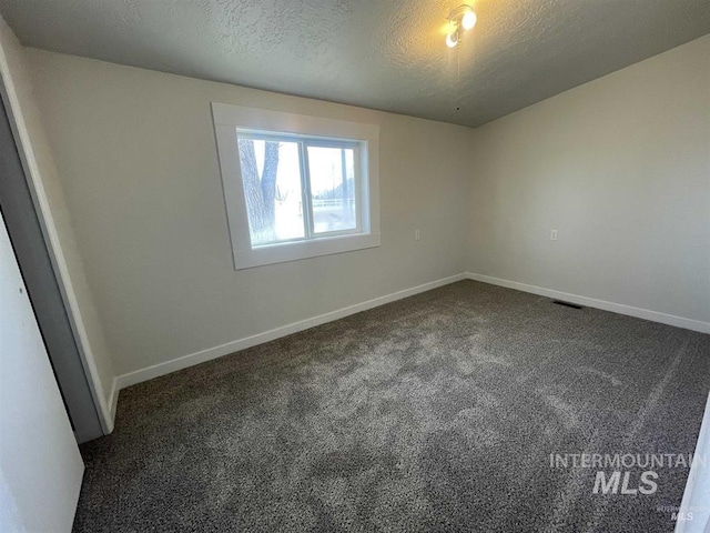 956 SE Hamilton Rd, Mountain Home, ID 83647 - spare room with dark carpet, a textured ceiling, and baseboards