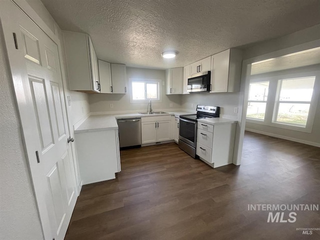956 SE Hamilton Rd, Mountain Home, ID 83647 - kitchen featuring stainless steel appliances, dark wood-type flooring, a sink, light countertops, and a textured ceiling