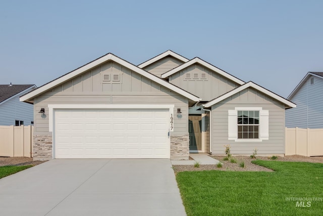 craftsman house with a garage and a front lawn