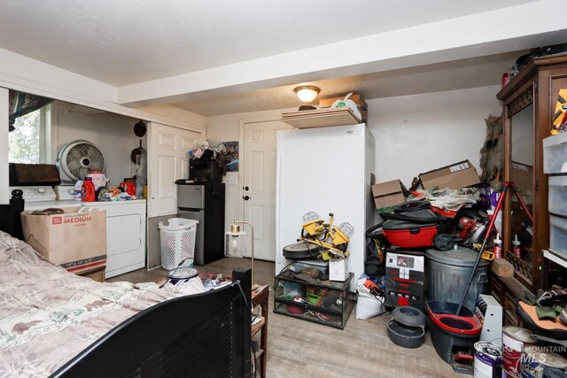 bedroom featuring washing machine and dryer and stainless steel fridge