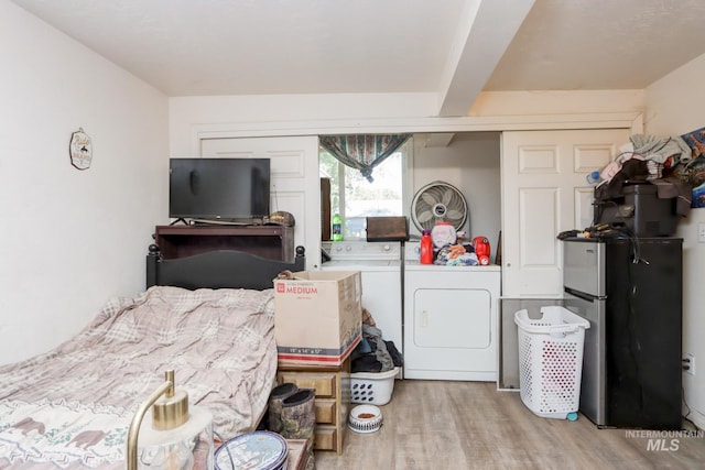 bedroom with light hardwood / wood-style floors, beamed ceiling, independent washer and dryer, a closet, and stainless steel fridge