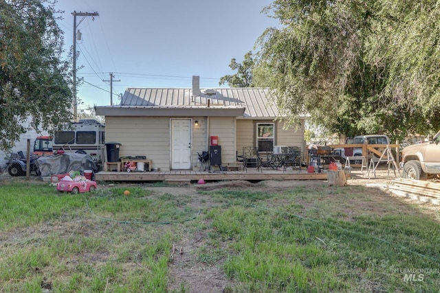 rear view of house with a deck and metal roof