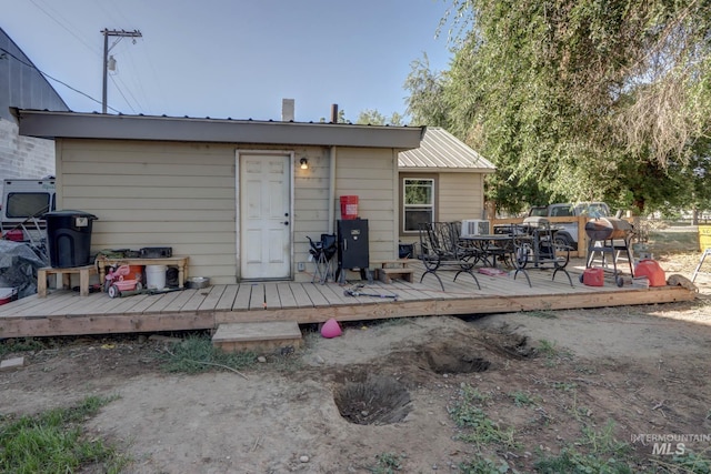 rear view of property featuring metal roof and a wooden deck