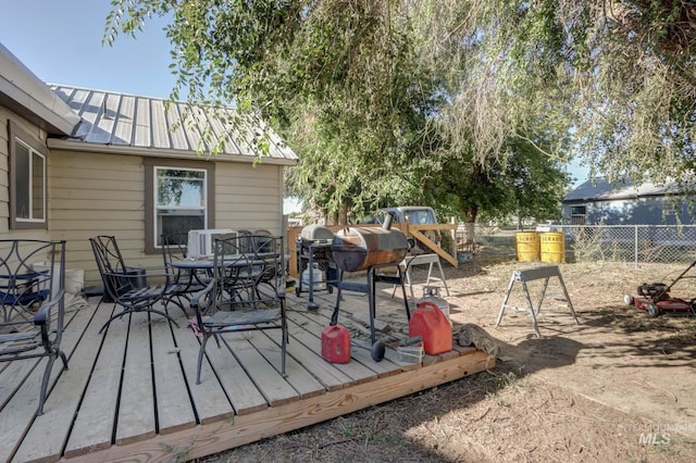 wooden terrace with outdoor dining space and fence