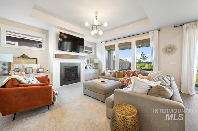 10411 Hazy Glen Dr, Nampa, ID 83687 - living area with a tray ceiling, a fireplace, and a chandelier