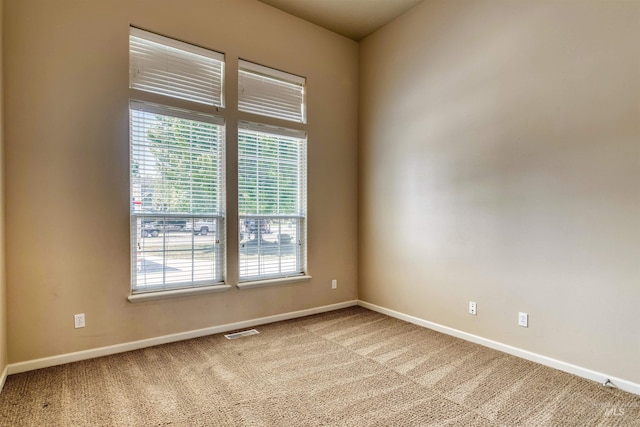 unfurnished room with carpet floors, baseboards, and visible vents