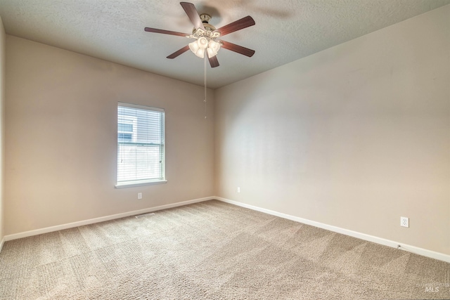 spare room featuring a ceiling fan, carpet, baseboards, and a textured ceiling