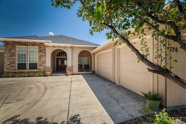 view of front of property with roof with shingles, stucco siding, concrete driveway, an attached garage, and stone siding