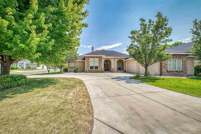 view of front of property featuring a garage, stone siding, concrete driveway, and a front yard