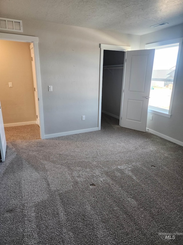 unfurnished bedroom featuring carpet flooring, a closet, and a textured ceiling