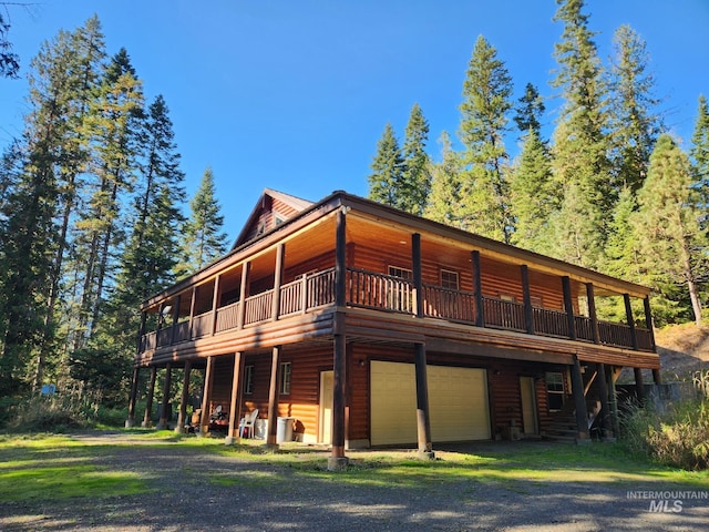 211 Resort Rd, Kooskia, ID 83539 - rear view of house featuring log veneer siding, dirt driveway, a garage, and a deck