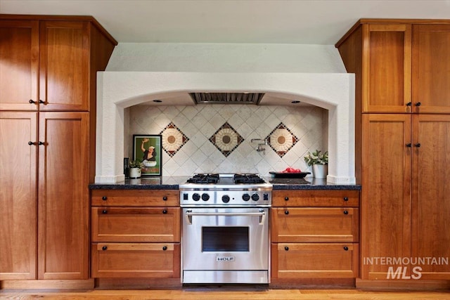 1814 E Spinnaker Ct, Boise, ID 83706 - kitchen with designer stove, decorative backsplash, brown cabinets, and dark stone countertops
