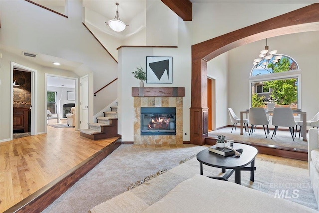 1814 E Spinnaker Ct, Boise, ID 83706 - living area featuring arched walkways, a fireplace, high vaulted ceiling, stairway, and a chandelier