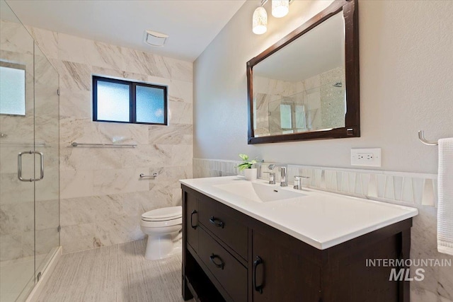1814 E Spinnaker Ct, Boise, ID 83706 - bathroom with tile walls, vanity, toilet, a stall shower, and wainscoting