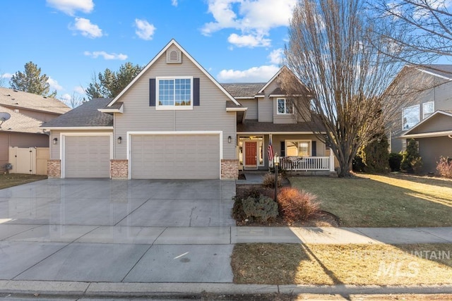 view of front of house featuring a garage, a front yard, and a porch