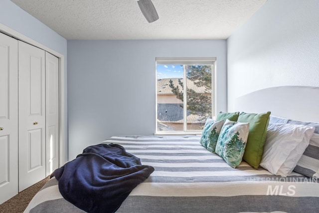 bedroom with ceiling fan, a textured ceiling, and a closet