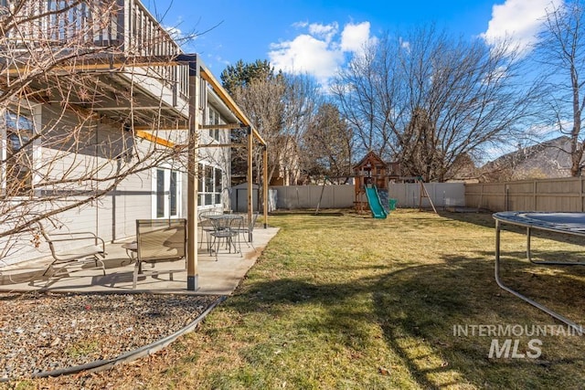 view of yard featuring a storage shed, a patio, a playground, and a trampoline