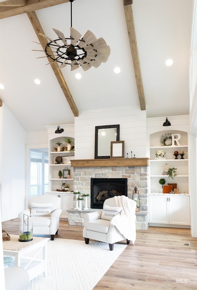 unfurnished living room featuring vaulted ceiling with beams, light hardwood / wood-style floors, and a stone fireplace