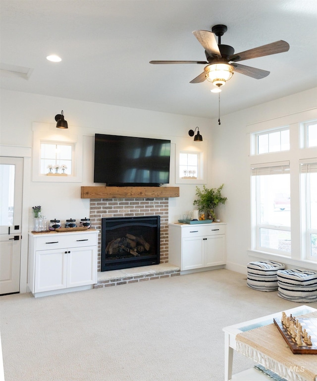 unfurnished living room with light carpet, a fireplace, and ceiling fan