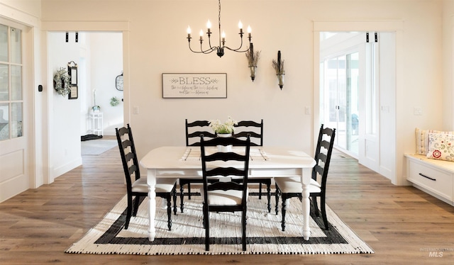 dining area with a chandelier and light hardwood / wood-style flooring