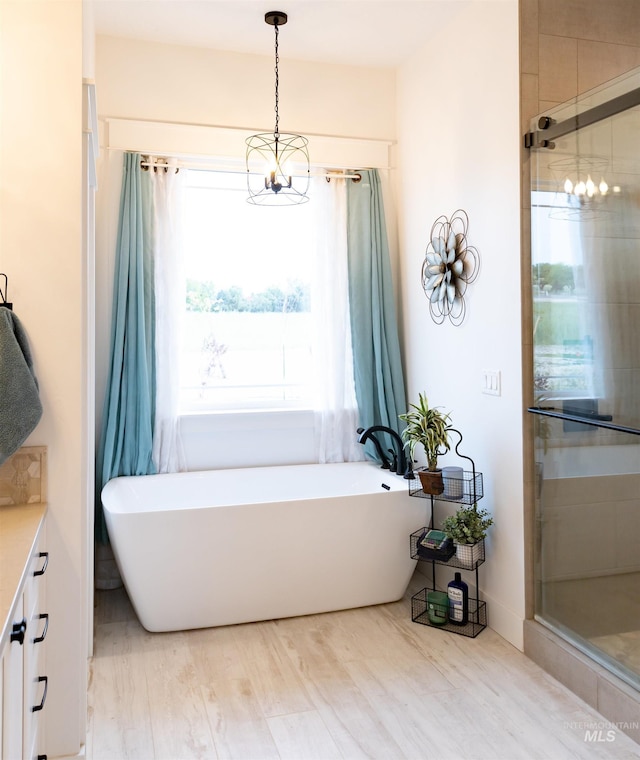 bathroom with hardwood / wood-style floors, vanity, and separate shower and tub