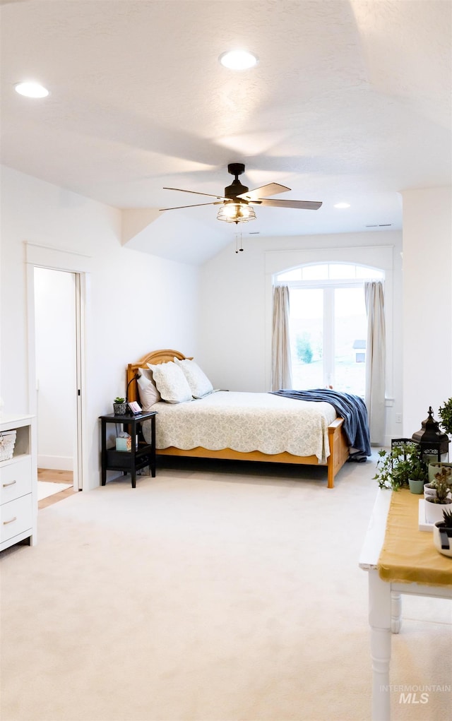 bedroom with light colored carpet, ceiling fan, and lofted ceiling