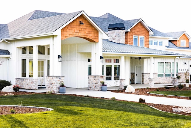 view of front of home with ceiling fan and a front lawn