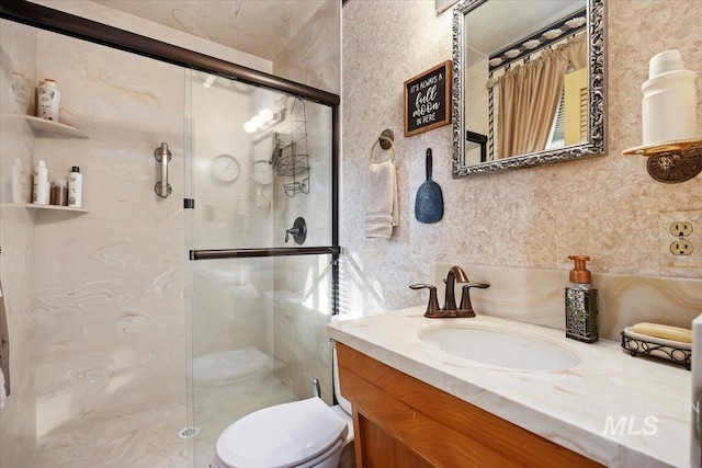 bathroom with a shower with door, vanity, and toilet