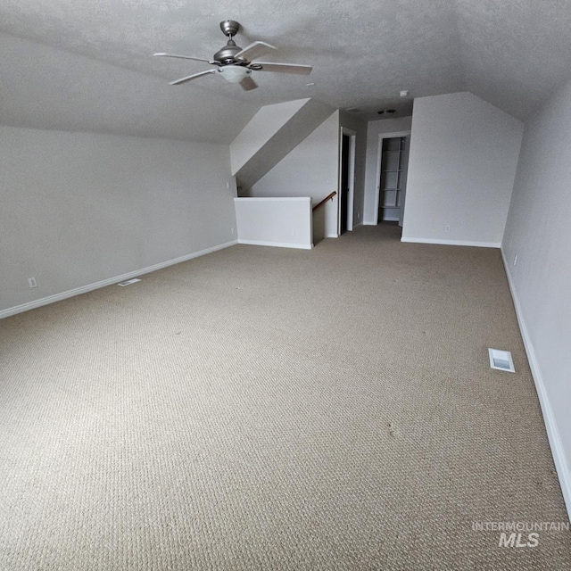 bonus room with a textured ceiling, carpet floors, ceiling fan, and lofted ceiling