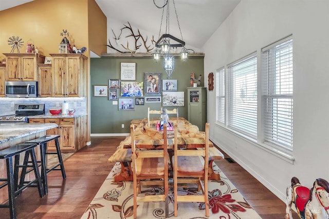 dining area with lofted ceiling, dark wood-style flooring, visible vents, and baseboards