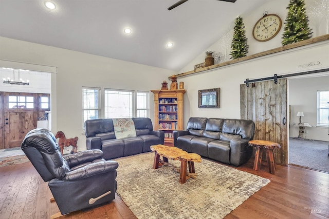 living room featuring plenty of natural light, a barn door, wood finished floors, and recessed lighting