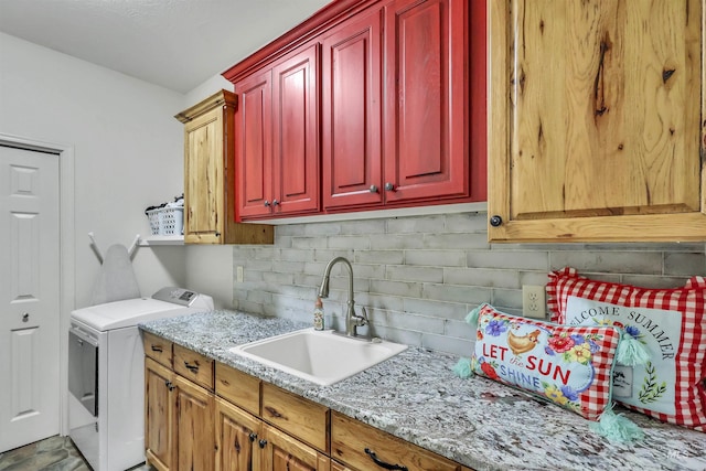 washroom featuring cabinet space, a sink, and washing machine and clothes dryer