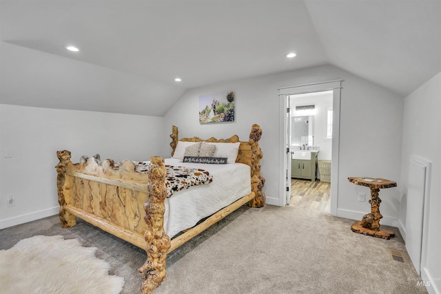 bedroom featuring carpet, a sink, vaulted ceiling, and baseboards