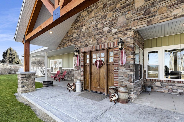 entrance to property with board and batten siding, stone siding, and covered porch